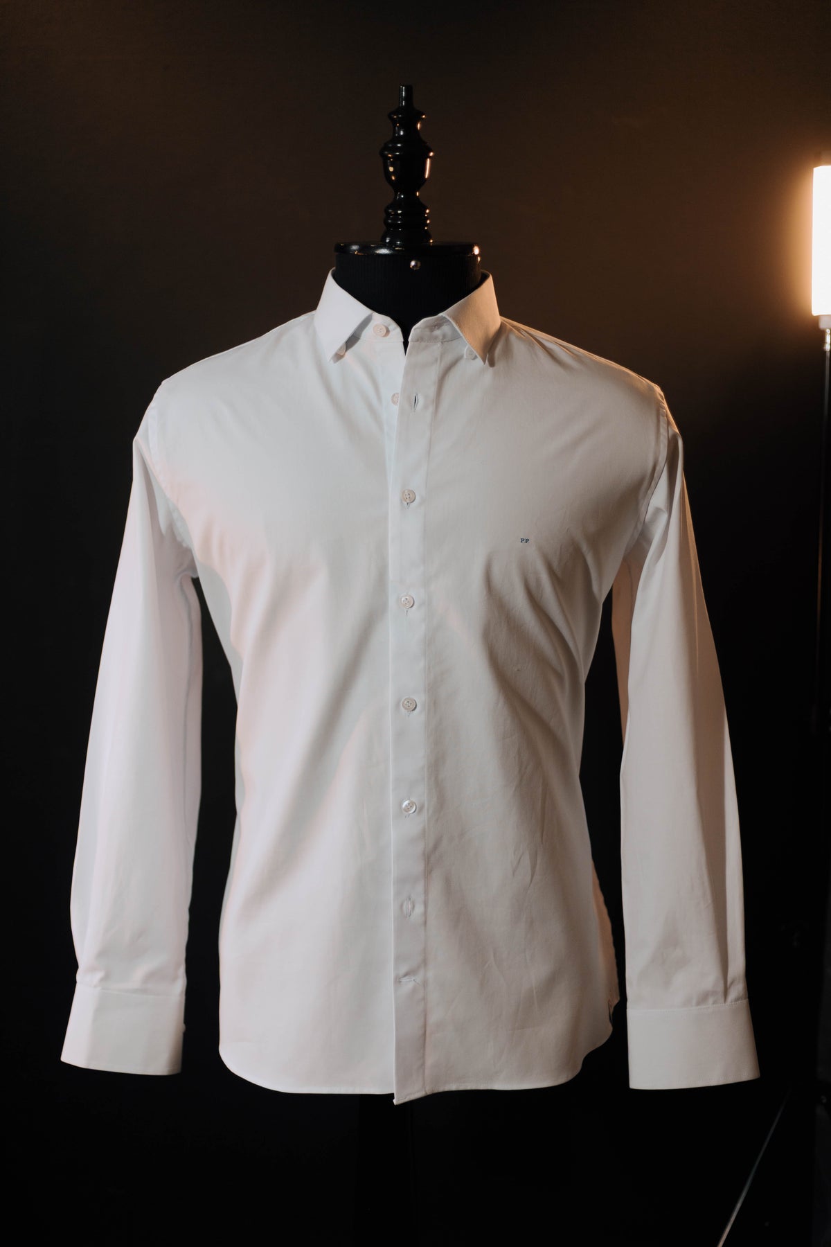 Camisa Gaspar Lopes branca em manequim de busto, sobre fundo escuro